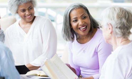 Three women reading and smiling